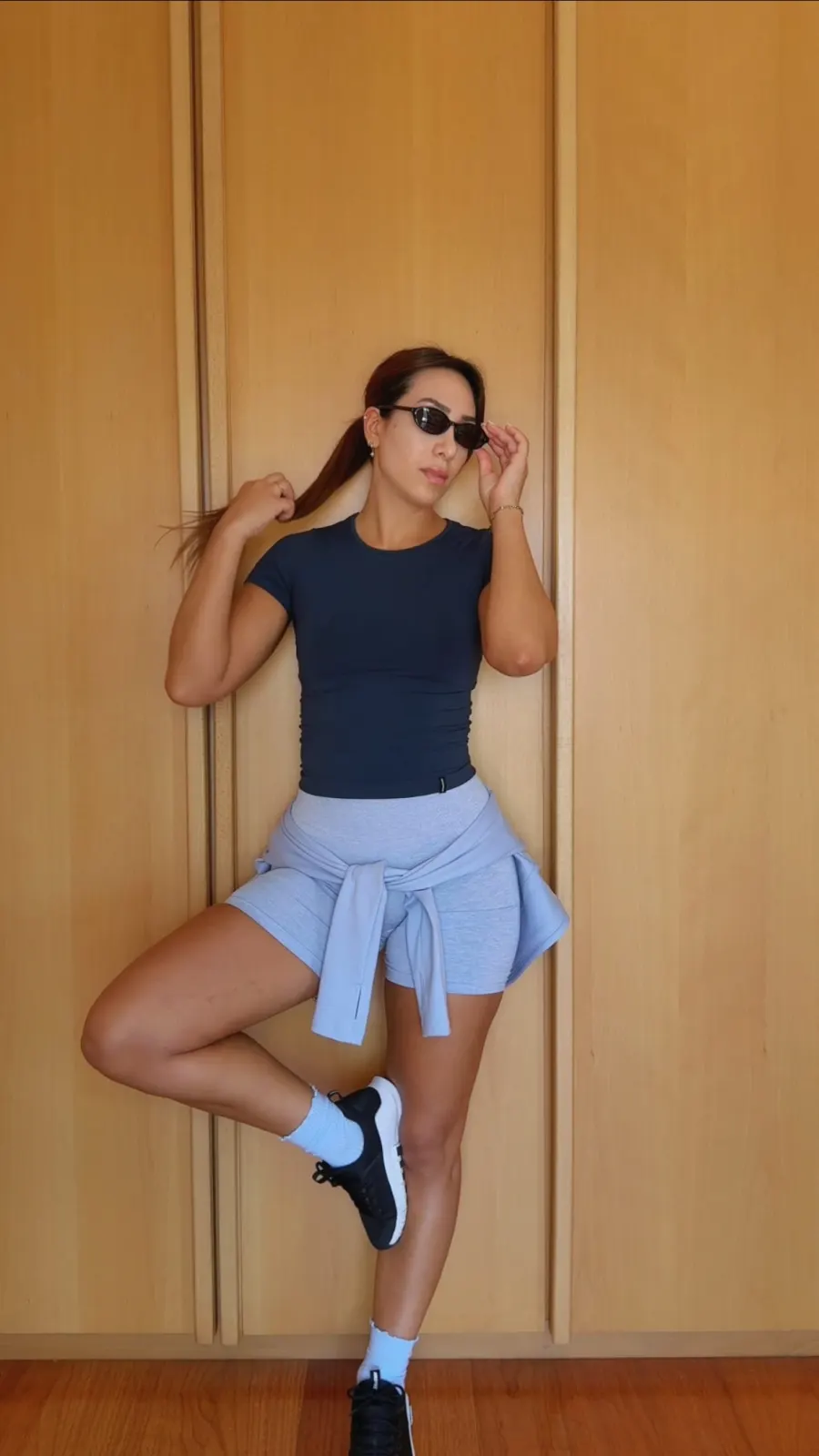 Flávia Nogueira em equilíbrio numa perna, de óculos de sol e roupa de treino